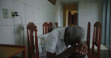 Yaşlı Afro-Amerikalı adam mutfakta oturmuş içten bir şekilde gülüyor ve gülüyordu. Huzurlu ve samimi bir evde mutluluk ve neşe ifade ediyordu.