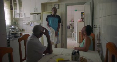 Afrika kökenli bir aile mutfakta toplandı. Yaşlı bir çift masada otururken bir adam yakınlarda, rahat ve samimi bir aile bağı ve günlük yaşam sürüyor.