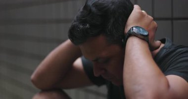 Duvara yaslanmış bir adam, kafası derin düşünce, duygusal yük, zihinsel sağlık sorunları, kişisel yansıma, yalnızlık ve şehir ortamında iç mücadele içinde.