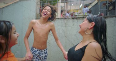 Bir grup mutlu genç açık havada eğleniyor, canlı bir toplulukta el ele tutuşuyorlar yukarıdan su püskürtüyor, arkadaşlığı ve neşeyi kutluyorlar.