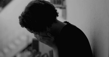 Afro-Amerikan çocuk duvara yaslanmış, yüzünü ellerle kaplamış, üzüntü ve yalnızlıkla boğulmuş, çocukluk bunalımını ve yalnızlığı simgeliyor.