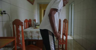 Yaşlı adam sandalyeden kalkar ve kararlılıkla yürür, direnç, bağımsızlık ve sonraki yaşamdaki günlük eylemlerin gücünü gösterir.