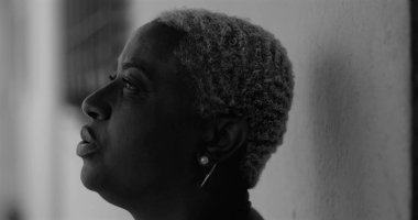 Afrika kökenli Amerikalı bir kadının derin duygusal karmaşa içinde yüzünü tek eliyle kapatması, üzüntü, pişmanlık, depresyon ve hassasiyet duygularını ifade etmesi, siyah beyaz