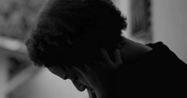 Kafasını duvara dayamış, umutsuzluk ve umutsuzluğu ifade eden, çocukluk depresyonu ve duygusal yalnızlık temalarını yansıtan Afrikalı Amerikalı bir çocuk.