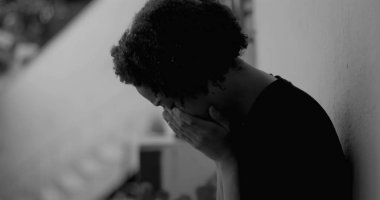 Afro-Amerikan çocuk duvara yaslanmış, yüzünü ellerle kaplamış, üzüntü ve yalnızlıkla boğulmuş, çocukluk bunalımını ve yalnızlığı simgeliyor.