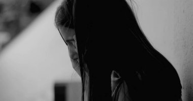 Duvara yaslanmış genç bir kız, kafası ellerde, üzüntü ve duygusal karmaşadan bunalmış, çocukluk bunalımını ve yalnızlığı tek renkli tonlarda resmediyor.