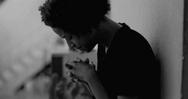 Afro-Amerikan çocuk duvara yaslanmış, yüzünü ellerle kaplamış, üzüntü ve yalnızlıkla boğulmuş, çocukluk bunalımını ve yalnızlığı simgeliyor.