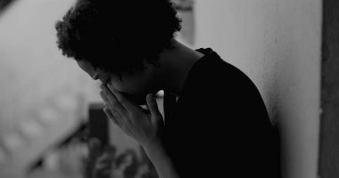 Afro-Amerikan çocuk duvara yaslanmış, yüzünü ellerle kaplamış, üzüntü ve yalnızlıkla boğulmuş, çocukluk bunalımını ve yalnızlığı simgeliyor.