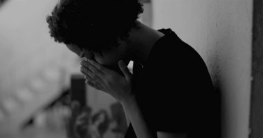 Afro-Amerikan çocuk duvara yaslanmış, yüzünü ellerle kaplamış, üzüntü ve yalnızlıkla boğulmuş, çocukluk bunalımını ve yalnızlığı simgeliyor.