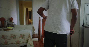 Yaşlı adam sandalyeden kalkar ve kararlılıkla yürür, direnç, bağımsızlık ve sonraki yaşamdaki günlük eylemlerin gücünü gösterir.