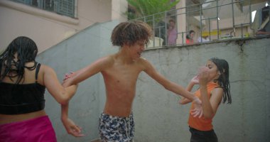 Çocuklar arka bahçede eğlenirken gülümseyip el ele tutuşurken neşeli ve kaygısız anılar yaratıyorlar.