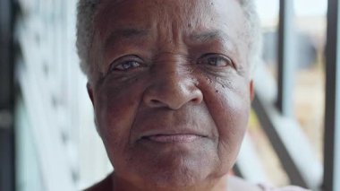 Ciddi ve içten bir bakışla, derin düşüncelere dalmış yaşlı bir kadının yakın çekimi. 