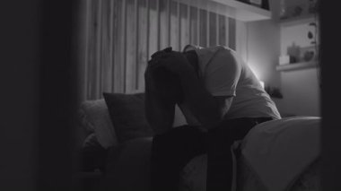 Orta yaşlı bir adam gecenin bir yarısı elleri başıyla yatakta oturuyor, suçluluk ve duygusal acıların üstesinden geliyor, derin üzüntü ve pişmanlığını sessizce yalnızlıkla ifade ediyor.