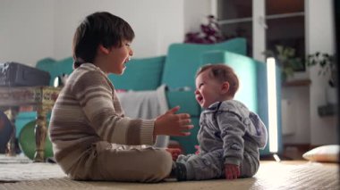 Ağabeyim oturma odasında bebeğe sarılıyor. Sıcak, güvenli ve sevgi dolu aile ortamında şefkat ve şefkat gösteriyor.