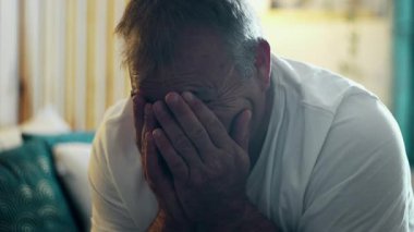 Orta yaşlı bir adam elinde yüzüyle yatakta oturuyor, duygularla boğulmuş, kederini, umutsuzluğunu ve kırılganlığını evcil ortamda aktarıyor.