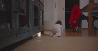 Daha yeni yürümeye başlayan çocuk, rahat aile evinde açık kapı eşiğine doğru emekliyor. Keşif, bağımsızlık ve çocukluk gelişiminin ilk aşamalarını temsil ediyor..