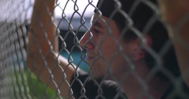 İspanyol bir adamın zincire vurduğu yakın plan açık alanda saldırgan bir hareketle öfkesini, umutsuzluğunu ve duygusal rahatlığını ifade ediyor.