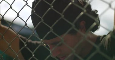 Kafası eğik, metal çitlere yaslanmış İspanyol bir adam derin düşüncelere dalmış, yorgunluğunu, hayal kırıklığını ya da dış mekan ortamındaki duygusal yansımasını ifade ediyor.