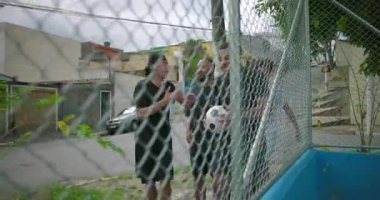 İspanyol arkadaşları futbol sahasına neşeli bir enerjiyle giriyor, oynamaya hazırlanırken gülümsüyor ve şakalaşıyorlar, arkadaşlığı, takım çalışmasını ve şehir ortamında eğlenmeyi kutluyorlar.