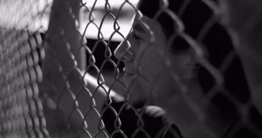 Çitin arkasındaki İspanyol adam derin düşüncelere dalmış, geçmişteki hataları ve siyah beyaz portredeki iç mücadeleyi yansıtıyor.