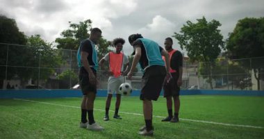 Genç İspanyol bir adam arkadaşlarıyla sıradan bir maç sırasında futbol topunu tekmeliyor, dengesini kaybediyor ve düşüyor takım arkadaşları neşe içinde gülüyor, rahat bir dostluk ve eğlence ortamı yaratıyor.