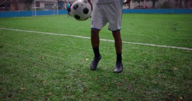 Afrika kökenli Latin erkek futbol sahasında tekmeleme, topun hassasiyet ve odaklanmayla dengelenmesi, disiplin, koordinasyon ve atletik gelişime adanmışlık kavramı