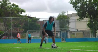 İspanyol adam sahada ısınıyor futbol maçından önce topun yanında koşuyor, maçtan önce konsantrasyon ve fiziksel hazırlık gösteriyor.