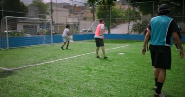 Mahalle sahasında gündelik futbol oynayan arkadaşlar, futbolcu topa gol puanı, takım çalışması, neşe ve tutku konseptine vuruyor.