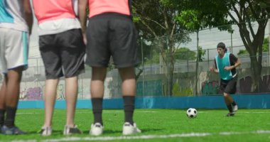 Yerel sahada gündelik futbol oynayan arkadaşlar, diğerleri savunma duvarında, takım çalışması, dinlenme ve halk sporları konseptinde dururken topa vurmaya hazırlanan bir oyuncu