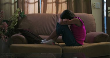 Kollarını dizlerine dolayıp bir kanepeye kıvırmış, yalnızlığını, üzüntüsünü ve duygusal sıkıntısını ifade eden, çocukluk depresyonu ve akıl hastalığının temalarını tasvir eden bir kız.