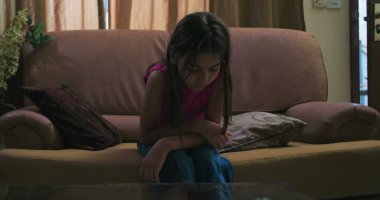 Kız kanepede yatar, kasvetli bir ifadeyle boş boş bakar, depresyon temalarını somutlaştırır, izolasyon ve genç iç gözlem sakin ama melankolik bir ortamda.