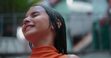 Suyun tadını çıkaran gülümseyen çocuk dışarıda, yüzü eğilmiş, gözleri kapalı, neşe saçan, sükunet ve neşeli, kaygısız bir ortamda doğayla bağlantı kuran çocuk.