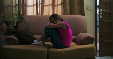 Genç kızın başını kollarının üzerinde dinlendirme, üzüntü, yalnızlık ve içgözlem, çocukluk depresyonu ve duygusal izolasyon temalarını vurgulama.