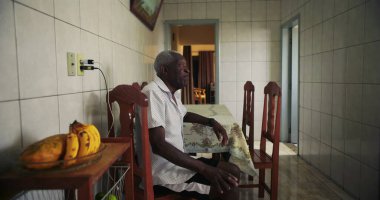 Afro-Amerikalı yaşlı bir adam, sakin bir bakışla, düşünceli bir bakışla ve sakin bir tavırla günlük hayatta nostalji ve memnuniyeti çağrıştırıyor.