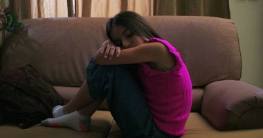 Genç kızın başını kollarının üzerinde dinlendirme, üzüntü, yalnızlık ve içgözlem, çocukluk depresyonu ve duygusal izolasyon temalarını vurgulama.