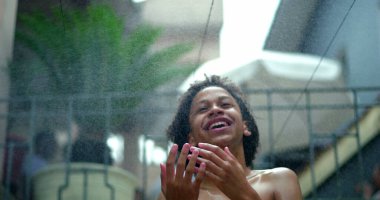 Suyun altında Afrika kökenli neşeli çocuk, hareketli saçlar, mutlulukla parıldayan yüz, kaygısız ve ferahlatıcı anları kucaklayan hayat dolu bir yaz sahnesi.