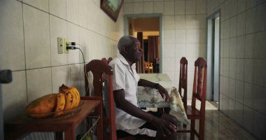 Afro-Amerikalı yaşlı bir adam, sakin bir bakışla, düşünceli bir bakışla ve sakin bir tavırla günlük hayatta nostalji ve memnuniyeti çağrıştırıyor.