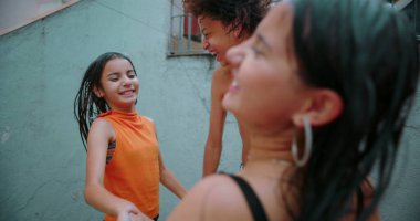 Gençlik kahkaha ve neşeyi paylaşıyor, canlı bir toplulukta arkadaşlığı ve eğlenceyi kucaklıyor, gülümsüyor ve yukarıdan suyla bağlantı kuruyor.