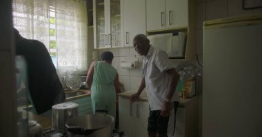 Afrika kökenli çok nesilli aile bir ev mutfağında birlikte yemek pişiriyor. Birlikte kesme, karıştırma, gözlemleme, kültür mirası ve birlik gösterme görevlerini paylaşıyorlar.