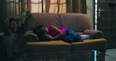 Kanepede uzanmış, kafası yastıkta dinleniyor, gözleri kapalı, yalnızlık, üzüntü, çocukluk bunalımı, ve sessiz bir ev ortamında duygusal hassasiyet temaları somutlaştırıyor.