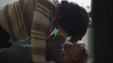 Bebek, yerde yatarken ağabeyinin saçını çekmek için uzanır. Sinir ve şefkat anı, gerçek kardeş samimiyetine ve erken duygusal öğrenime karışır.