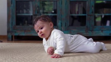 Evdeki yumuşak paspasın üzerinde emekleyen bebek.