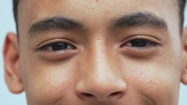 Çocuğun yüzüne aşırı yakın çekim. Gözlere ve buruna pürüzsüz bir cilt dokusu ve sakin bir ifadeyle odaklanma.