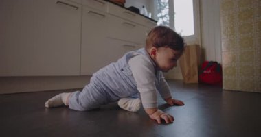 Bebek, mutfak zemininde kol ve bacaklardaki ağırlığı destekliyor. Erken gelişimin ilk aşamalarını ve gücünü gösteriyor.