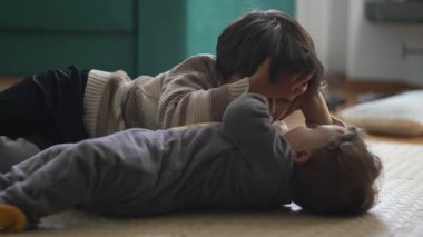 Bebek yerde yatıp ağabeyi saçlarını çekiyor, ikisi de şefkat ile karışık sessiz bir mücadele içindeler, evde merak, sabır ve gerçek kardeş bağlarını ifade ediyorlar.