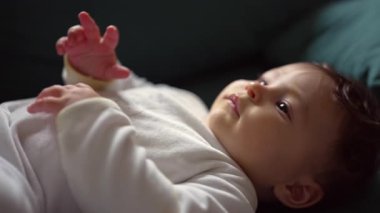 Bebek tulumlu bebek evde kanepede yatıyor.