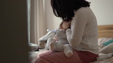 Anne evde bebeğini emzirirken, anne ve baba ile çocuk arasındaki yakın beslenme, şefkat ve duygusal bağ anlarını yaşıyor.