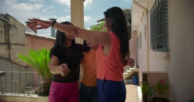 Güney Amerika 'nın geleneksel unsurları ve bitkileriyle dolu bir yerleşim bölgesinde, şefkat ve şefkat gösteren bir anne, açık havada kızını kucaklıyor.