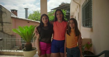 Anne ve iki kızı, Güney Amerika 'da bir verandada kol kola durmuşlar. Barışçıl bir aile ortamında sevgi ve birlik içindeler.