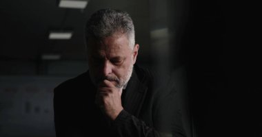 İşletme yöneticisi, şirket yönetim kurulu toplantısında arka planda performans çizelgeleriyle el pençe divan dururken düşüncelere daldı.